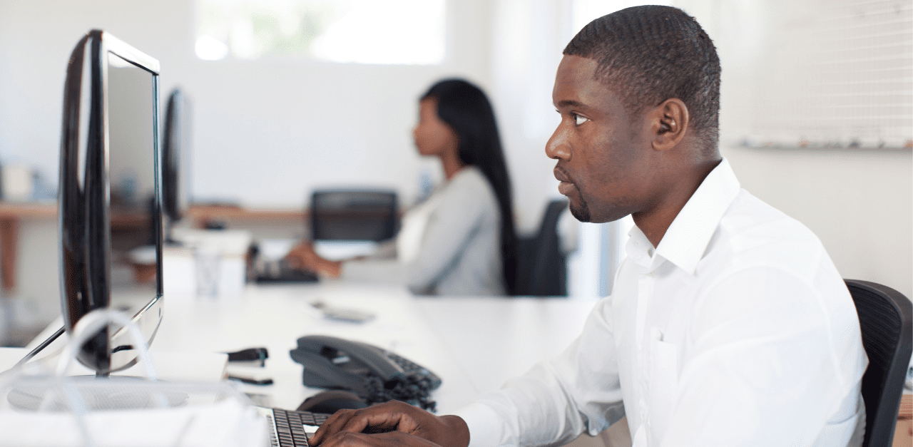 Preparation in Focus: CAE Absorbing Boardroom Insights A dedicated CAE engrossed in reading the white paper 'A Chief Audit Executive's Checklist for Getting Boardroom Ready' at his desk.